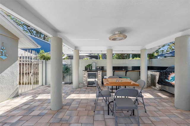 view of patio / terrace featuring area for grilling, ceiling fan, and beverage cooler