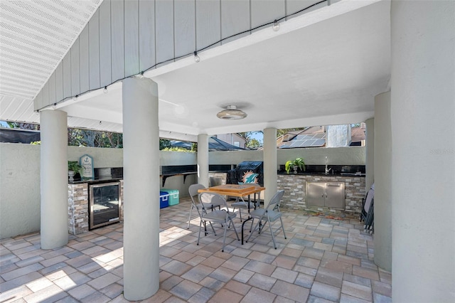 view of patio featuring wine cooler and an outdoor kitchen