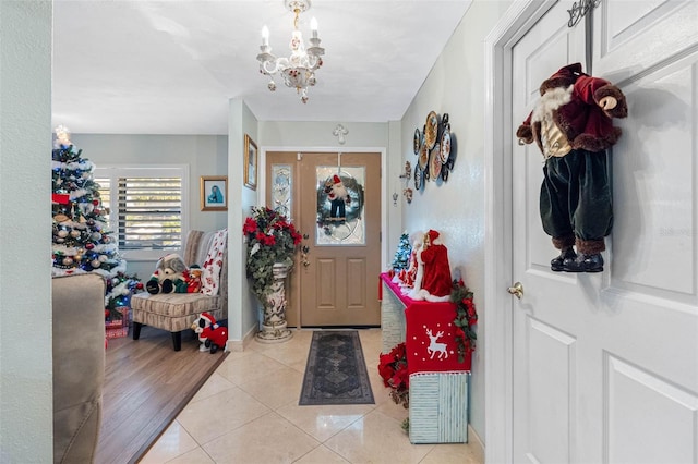 tiled foyer entrance featuring an inviting chandelier