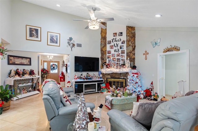 living room featuring a fireplace, light tile patterned floors, and ceiling fan with notable chandelier