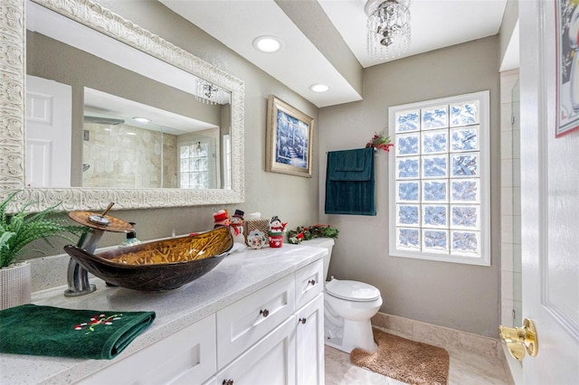 bathroom with a tile shower, tile patterned floors, vanity, and toilet