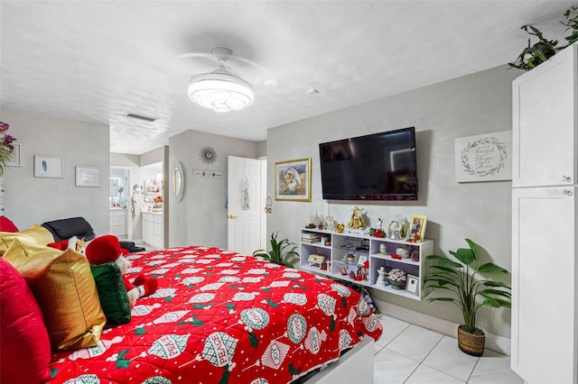 tiled bedroom featuring a textured ceiling and ensuite bath