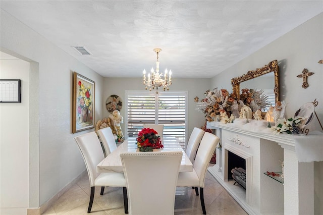 dining room with light tile patterned floors, baseboards, visible vents, and a notable chandelier