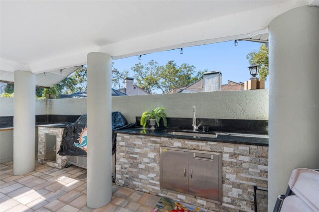 view of patio with exterior kitchen, a fenced backyard, and a sink