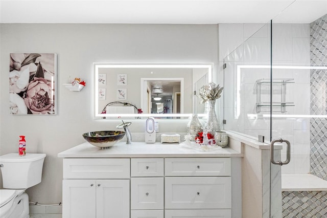 bathroom featuring a stall shower, vanity, and toilet