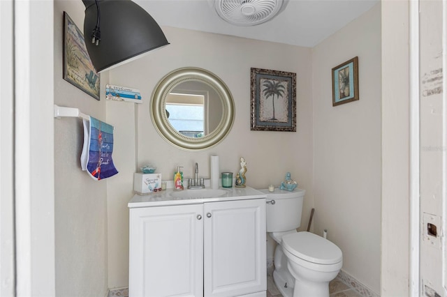 half bathroom with toilet, vanity, and visible vents