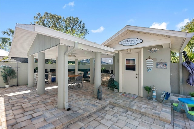 view of patio / terrace with exterior kitchen, outdoor dining area, and fence