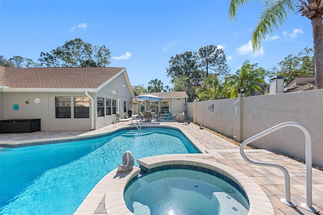 view of swimming pool featuring a patio, fence, and a pool with connected hot tub