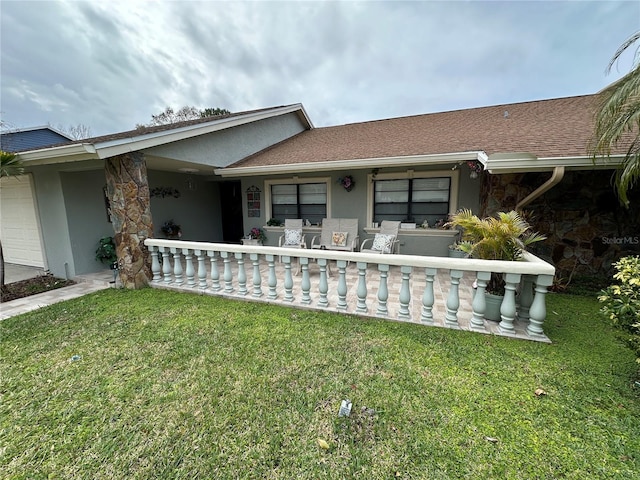 view of front of house featuring a porch, stone siding, a front yard, and stucco siding