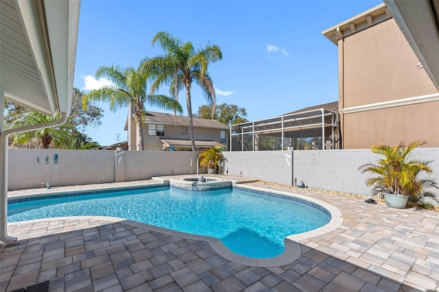 view of pool featuring a fenced backyard, a patio, a pool with connected hot tub, and glass enclosure