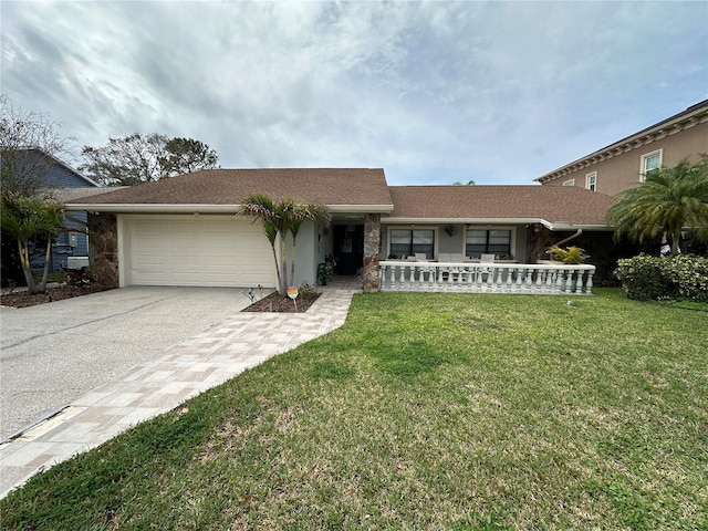 single story home with concrete driveway, stone siding, covered porch, an attached garage, and a front yard