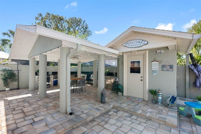 view of patio / terrace with fence, an outdoor bar, a gazebo, and exterior kitchen