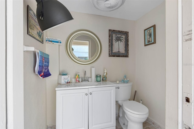 half bathroom with visible vents, tile patterned flooring, vanity, and toilet