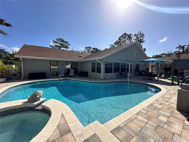 pool with a patio and an in ground hot tub