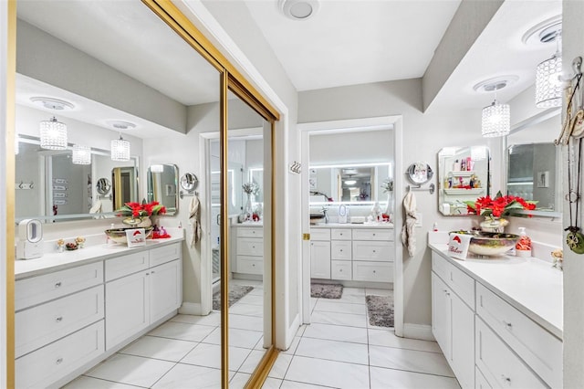 4608 Apple Ridge Ln, Tampa, FL 33624 - bathroom with two vanities, tile patterned floors, and baseboards