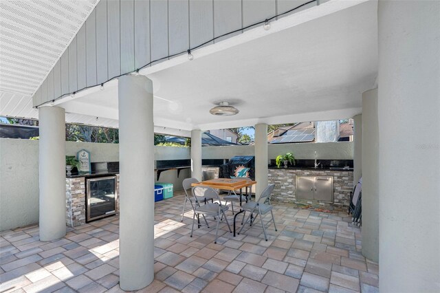 4608 Apple Ridge Ln, Tampa, FL 33624 - view of patio / terrace featuring exterior kitchen, wine cooler, fence, a sink, and outdoor dining space