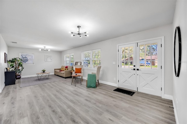 foyer with light hardwood / wood-style floors, a wealth of natural light, and a chandelier