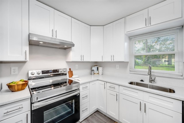 kitchen with sink, electric range, light wood-type flooring, and white cabinetry