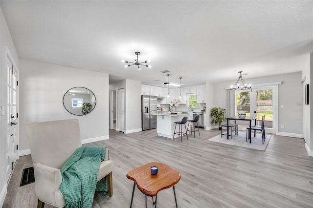 living room featuring light hardwood / wood-style flooring and an inviting chandelier