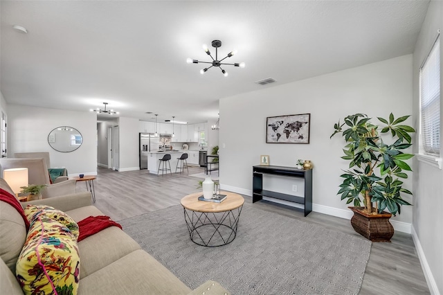 living room with a chandelier and light wood-type flooring