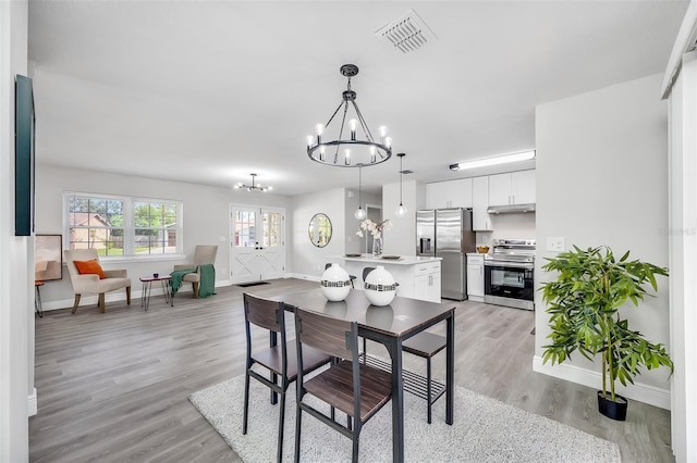 dining space featuring a notable chandelier and light hardwood / wood-style flooring