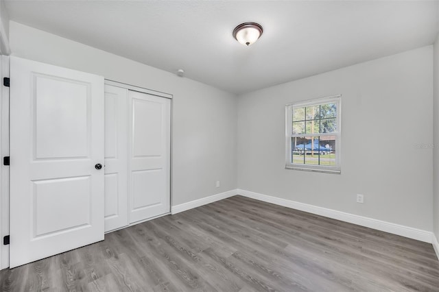 unfurnished bedroom featuring a closet and light wood-type flooring