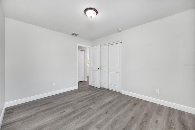 unfurnished bedroom with a closet and hardwood / wood-style flooring