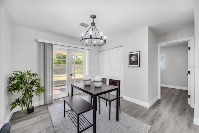 dining room featuring french doors, light hardwood / wood-style flooring, and a notable chandelier