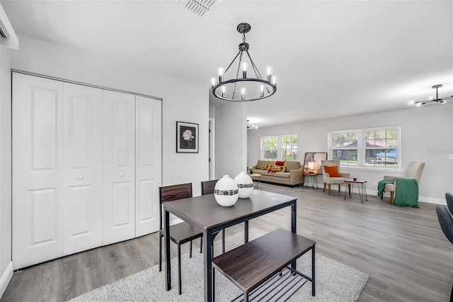 dining room with a notable chandelier and light wood-type flooring