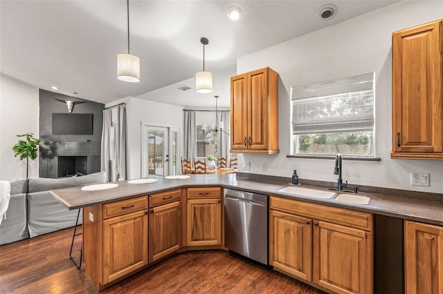 kitchen featuring dishwasher, a kitchen breakfast bar, dark wood-type flooring, kitchen peninsula, and pendant lighting