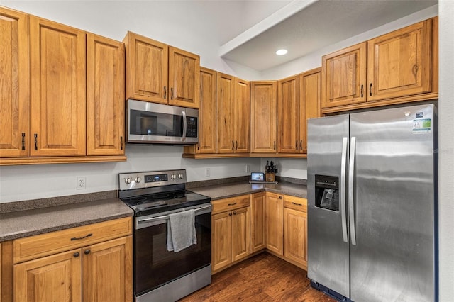 kitchen featuring appliances with stainless steel finishes and dark hardwood / wood-style floors