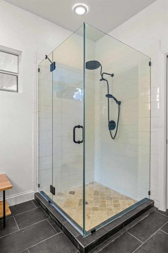 bathroom featuring a shower with door and tile patterned floors