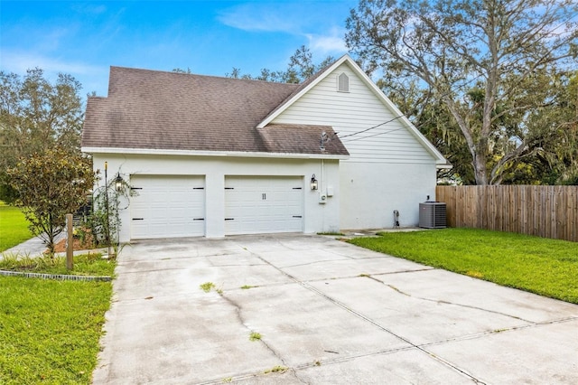 view of property exterior featuring central AC, a garage, and a lawn