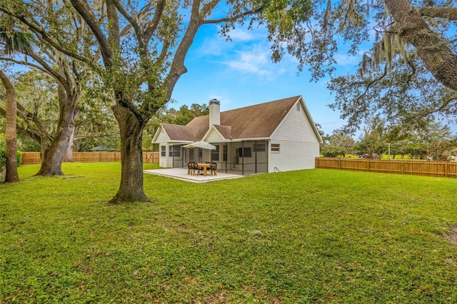 rear view of property featuring a yard and a patio area