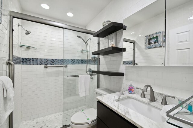 bathroom with toilet, a stall shower, vanity, decorative backsplash, and recessed lighting
