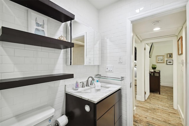 bathroom with toilet, wood finished floors, and vanity