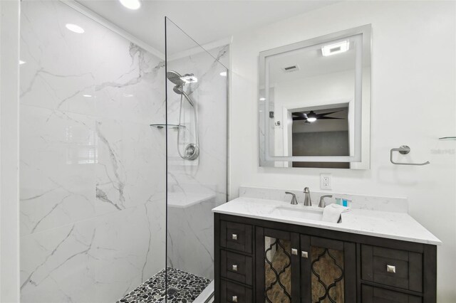 bathroom featuring a marble finish shower, vanity, and a ceiling fan