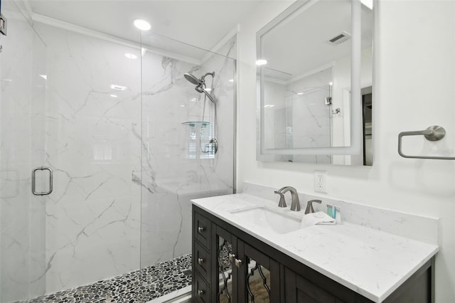 bathroom featuring a marble finish shower, visible vents, crown molding, and vanity