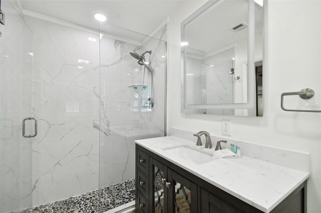 full bath with a marble finish shower and vanity