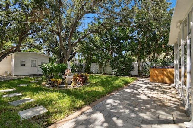 view of yard featuring a fenced backyard, a patio, and an outdoor structure