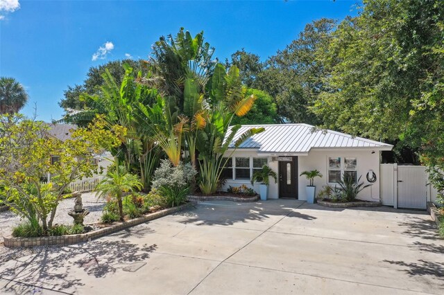 view of front of house with a gate, stucco siding, fence, and driveway