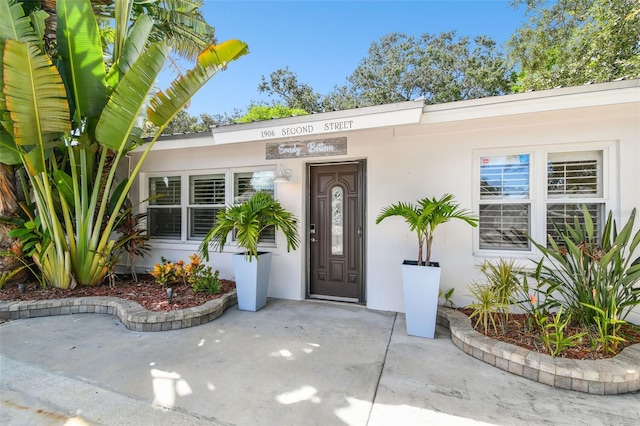 view of exterior entry with stucco siding