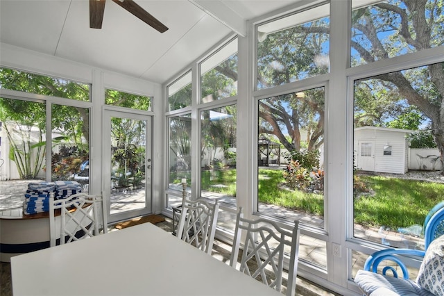 sunroom / solarium with lofted ceiling and a ceiling fan