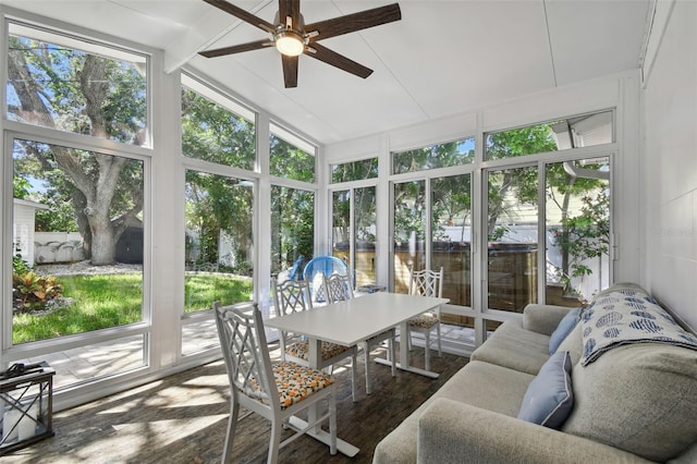 sunroom / solarium featuring vaulted ceiling with beams, a wealth of natural light, and a ceiling fan