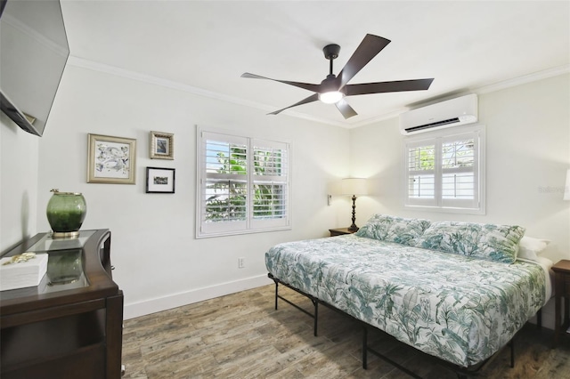 bedroom with ornamental molding, a wall unit AC, and wood finished floors