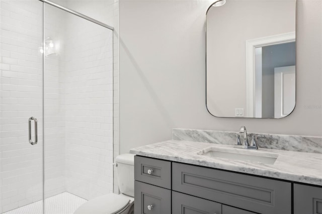 bathroom with vanity, toilet, and an enclosed shower