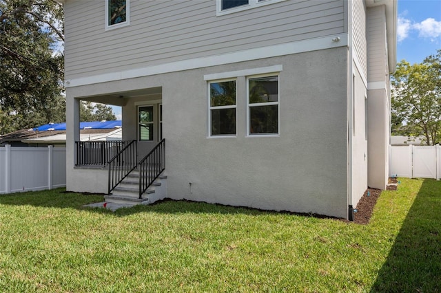 back of house featuring a lawn