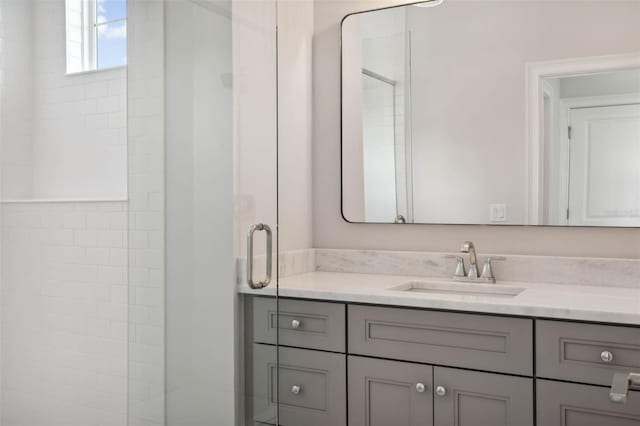 bathroom featuring walk in shower and vanity