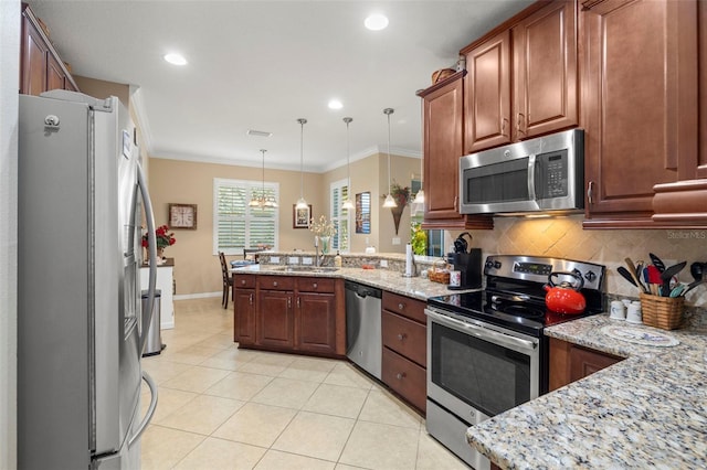 kitchen with ornamental molding, appliances with stainless steel finishes, light stone counters, and pendant lighting