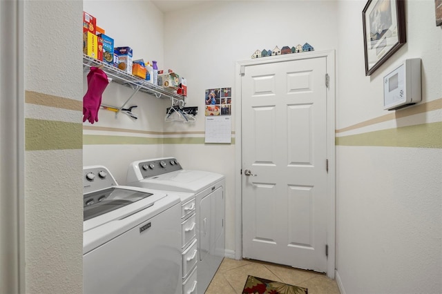 washroom featuring washer and clothes dryer and light tile patterned flooring